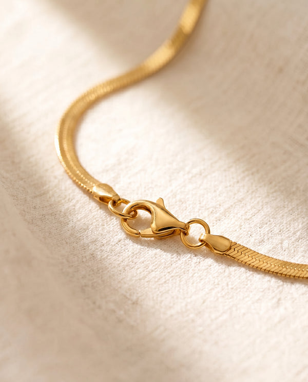 Gold lobster claw clasp close-up on snake chain