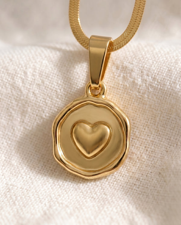Love Note heart pendant close-up on gold snake chain