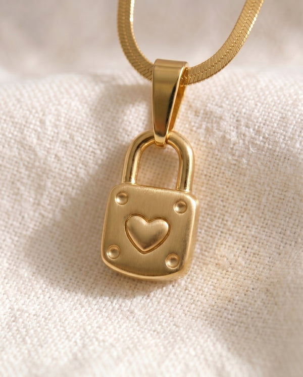 Little by Little Lock pendant close-up on gold snake chain