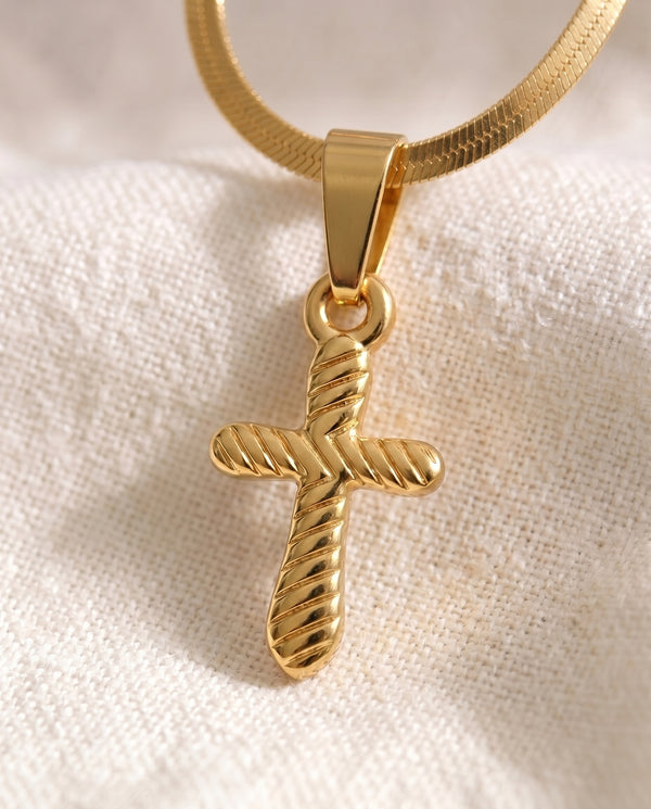 Quiet Devotion Cross pendant close-up on gold snake chain