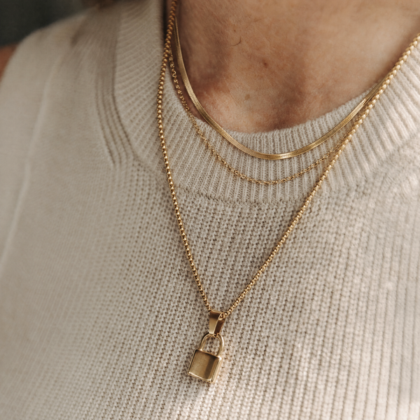 The Everyday Stack — layered gold necklaces and pendant on a model