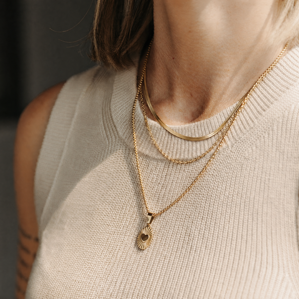 The Just as You Are Stack — layered gold necklaces and pendant on a model
