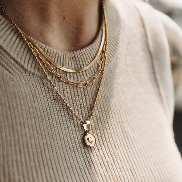 The Love Note Stack — layered gold necklaces and pendant on a model